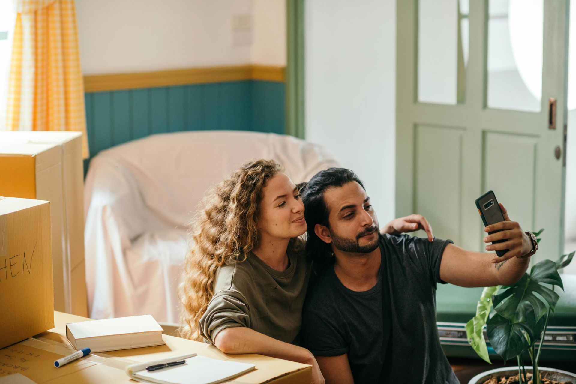 A man and a woman are taking a selfie in their new home.