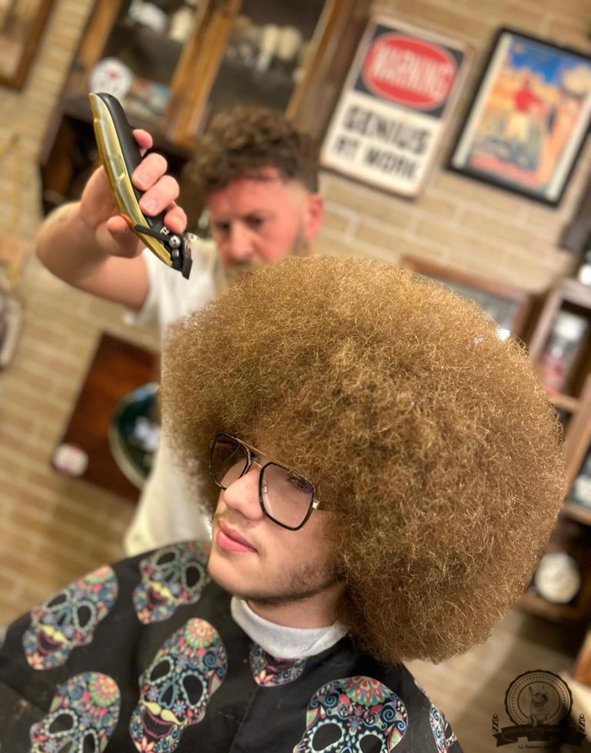 Un uomo con un grande afro si sta facendo tagliare i capelli dal barbiere.