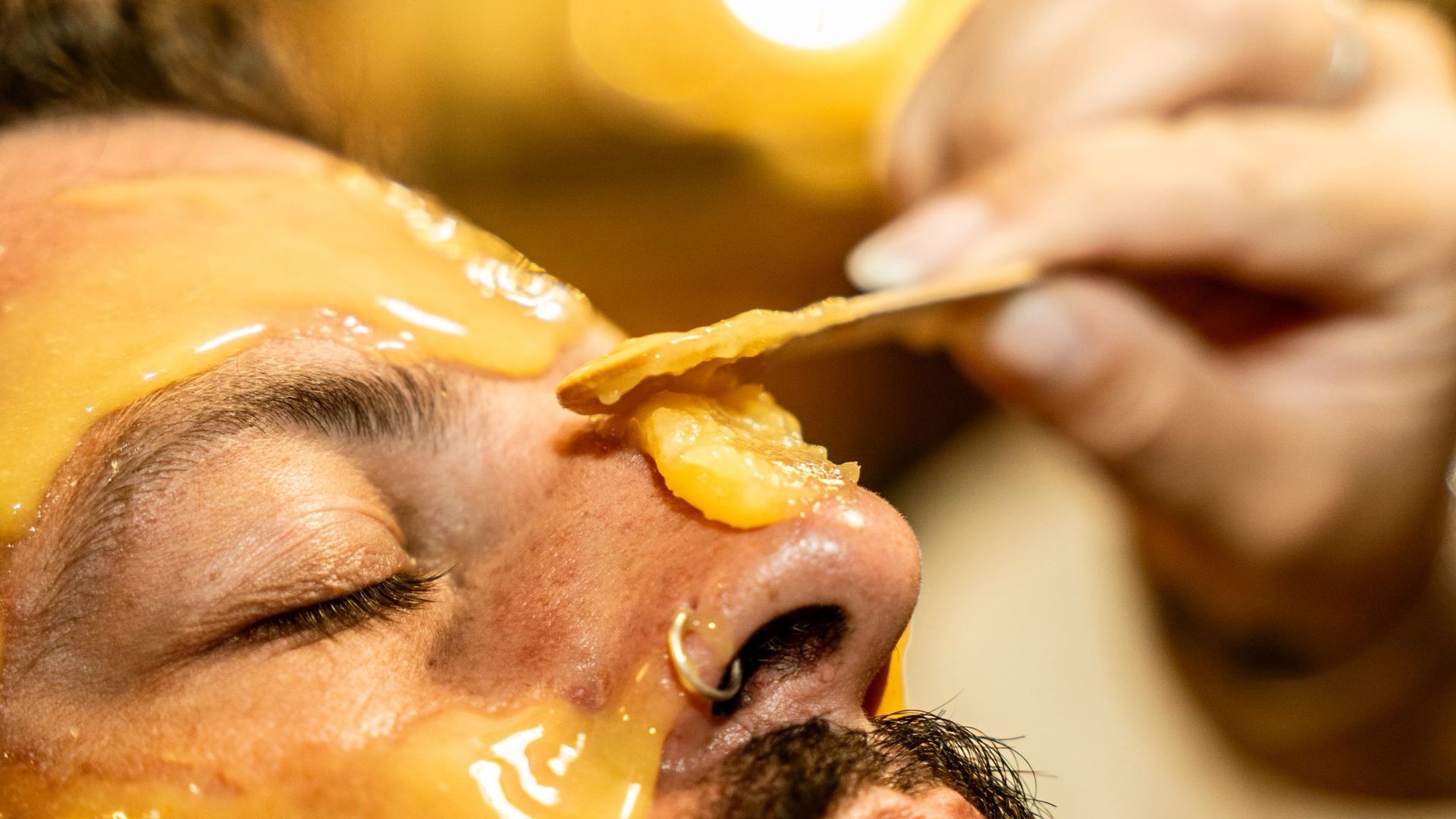 Maschera alla curcuma sul viso di un uomo 