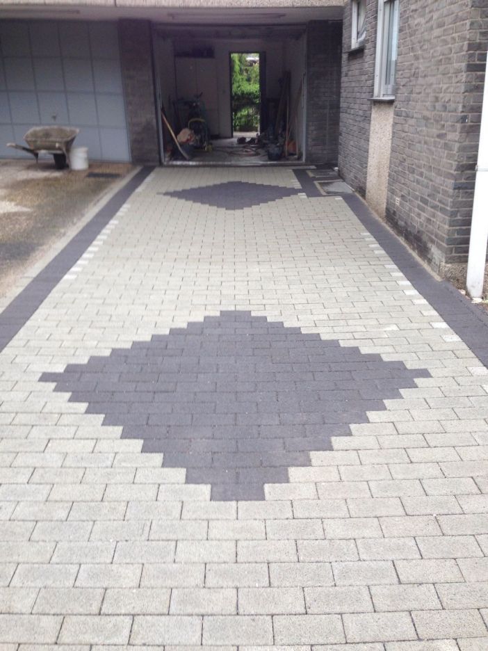 Stone patio leading toward a manicured lawn with hedges and bushes.