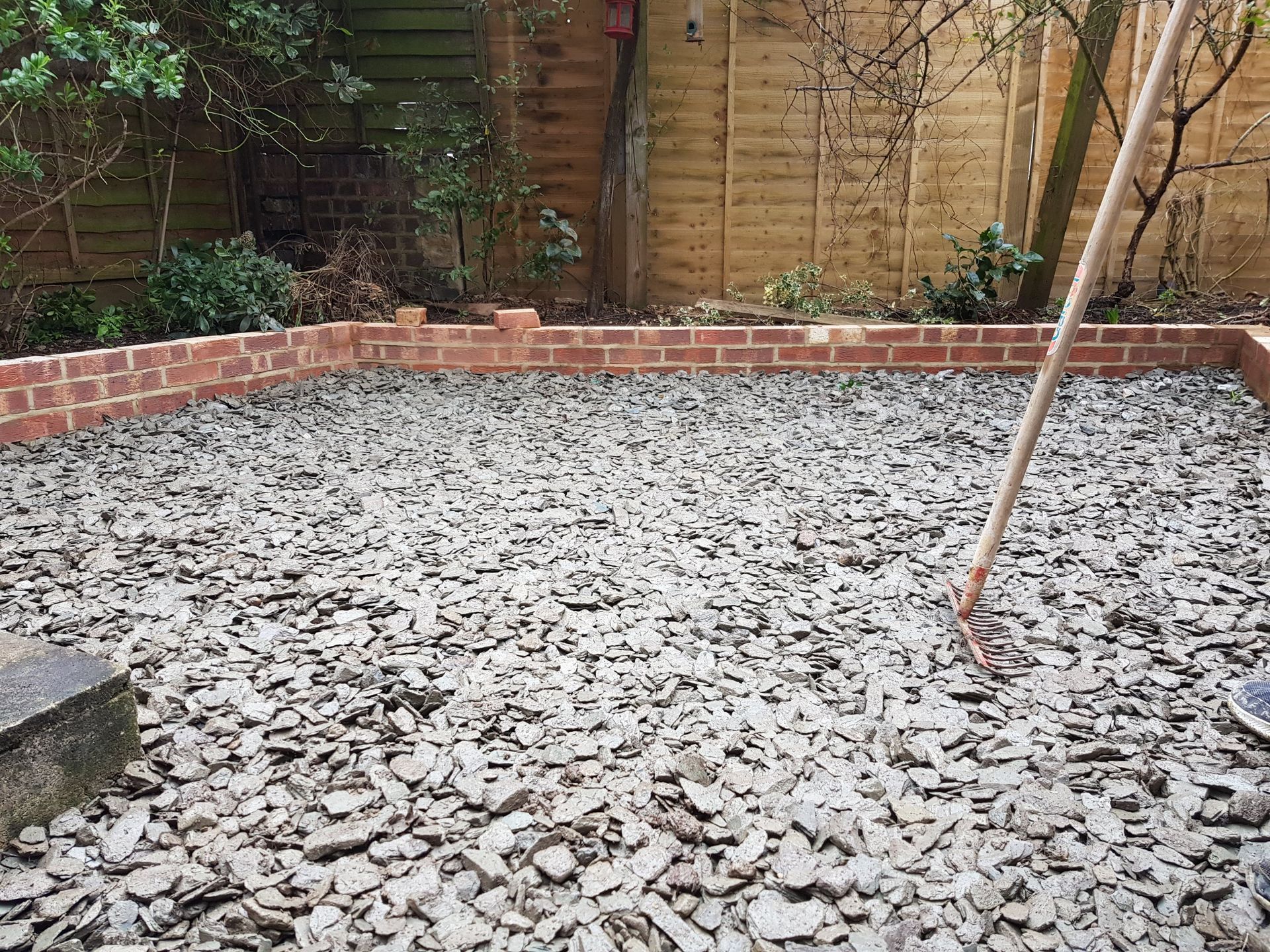 Patio under construction; paving stones scattered. A person in the background.