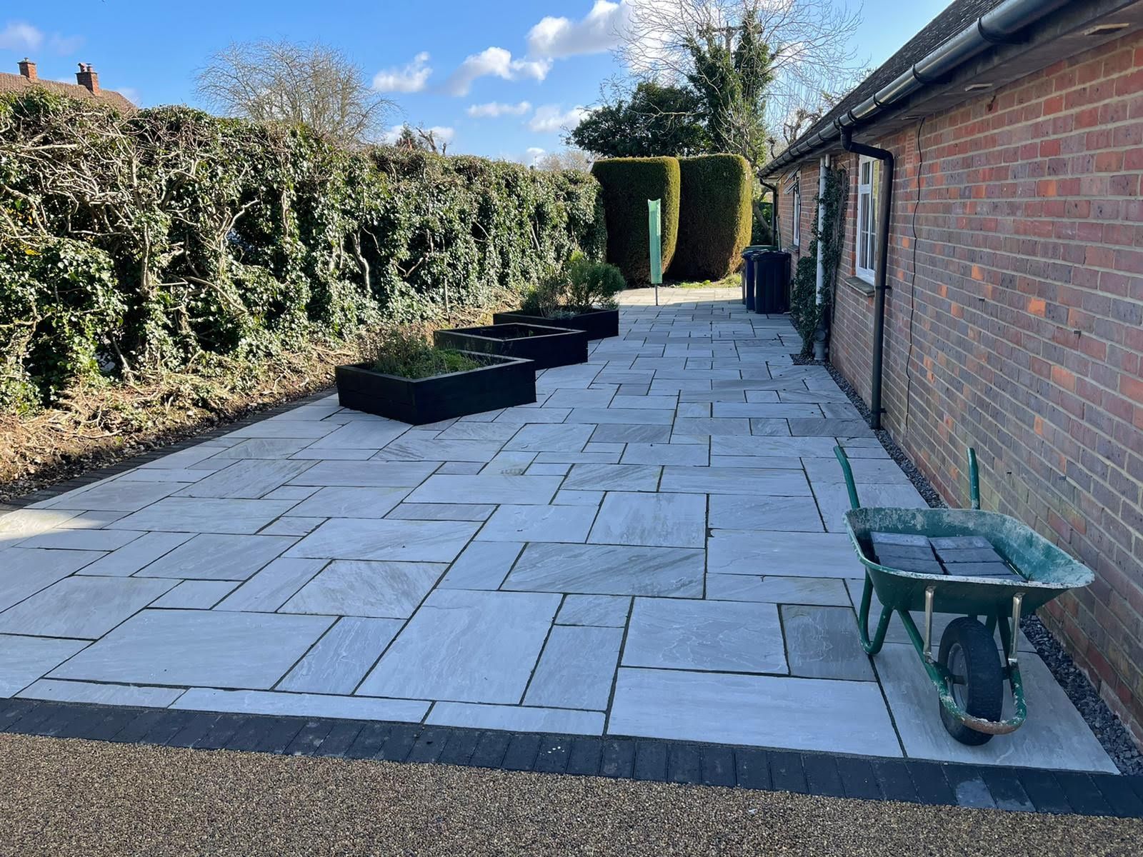 Patio under construction; paving stones scattered. A person in the background.