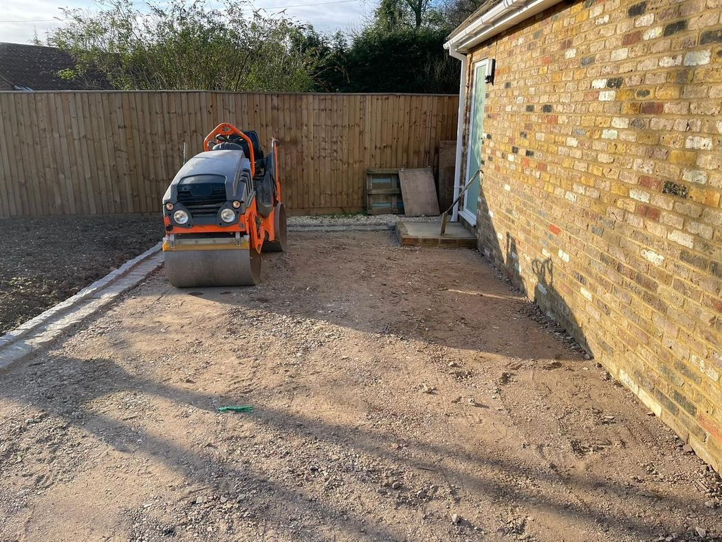 Patio under construction; paving stones scattered. A person in the background.