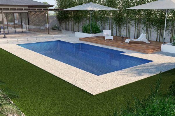 Backyard pool with blue water, white stone deck, loungers, umbrella, and bamboo privacy screen