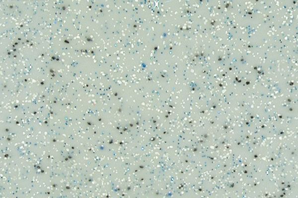 Speckled pale green surface with scattered dark dots and tiny light flecks