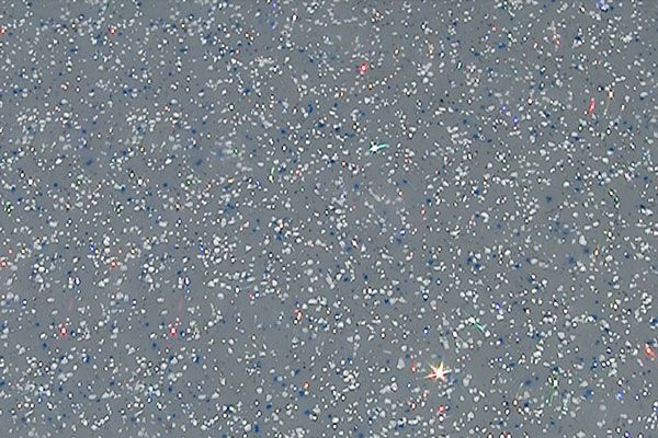 Gray speckled abstract background with a small bright star-like light near the bottom center