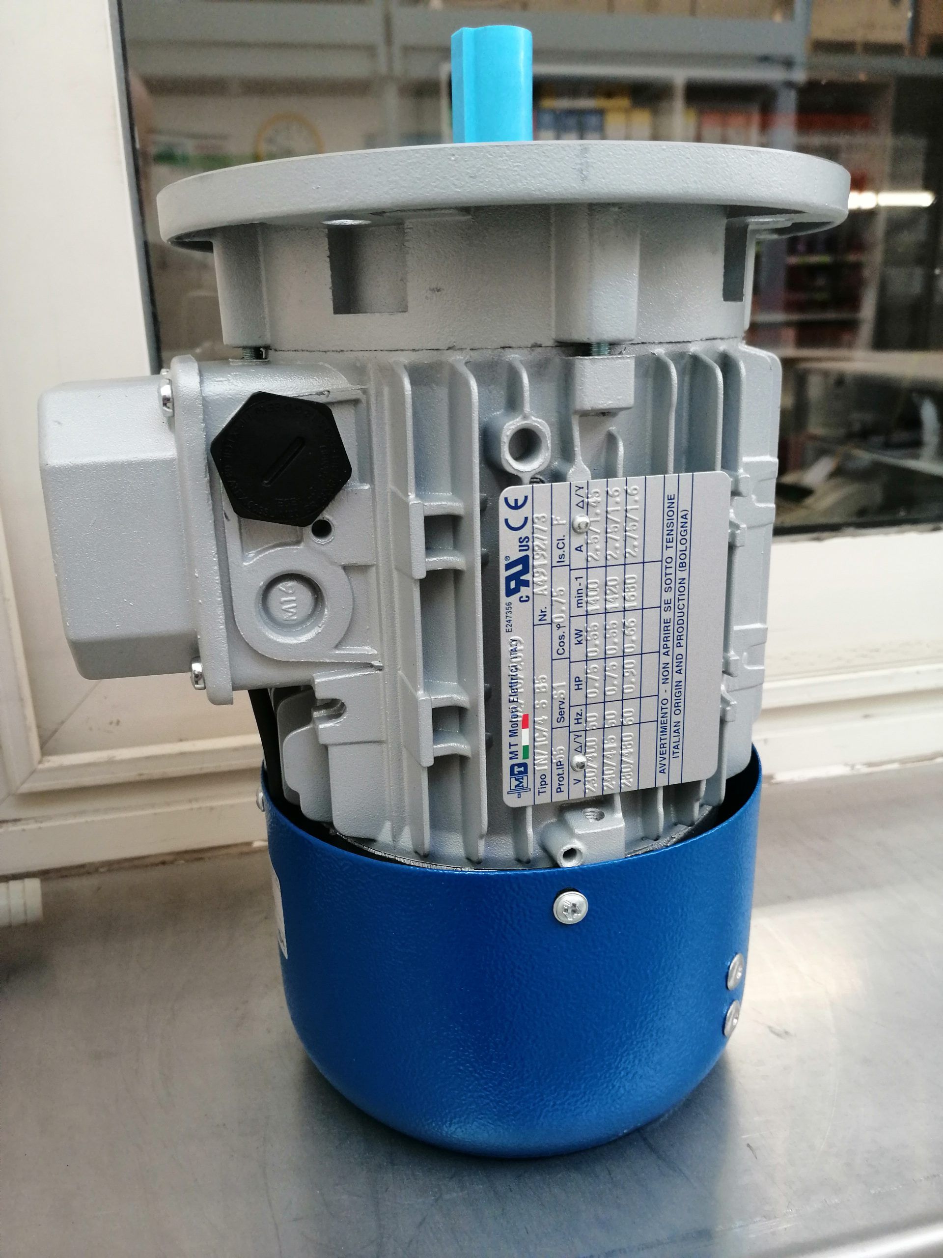 Motore elettrico, argento e blu, su una superficie in acciaio inossidabile, all'interno.