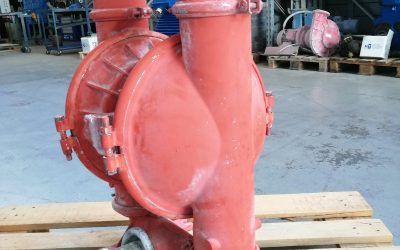 Pompa industriale rossa su un pallet di legno; sullo sfondo si vede un'altra pompa simile.