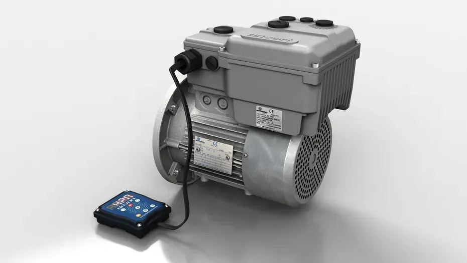Motore elettrico collegato a un pannello di controllo blu, alloggiamento grigio, su una superficie grigio chiaro.