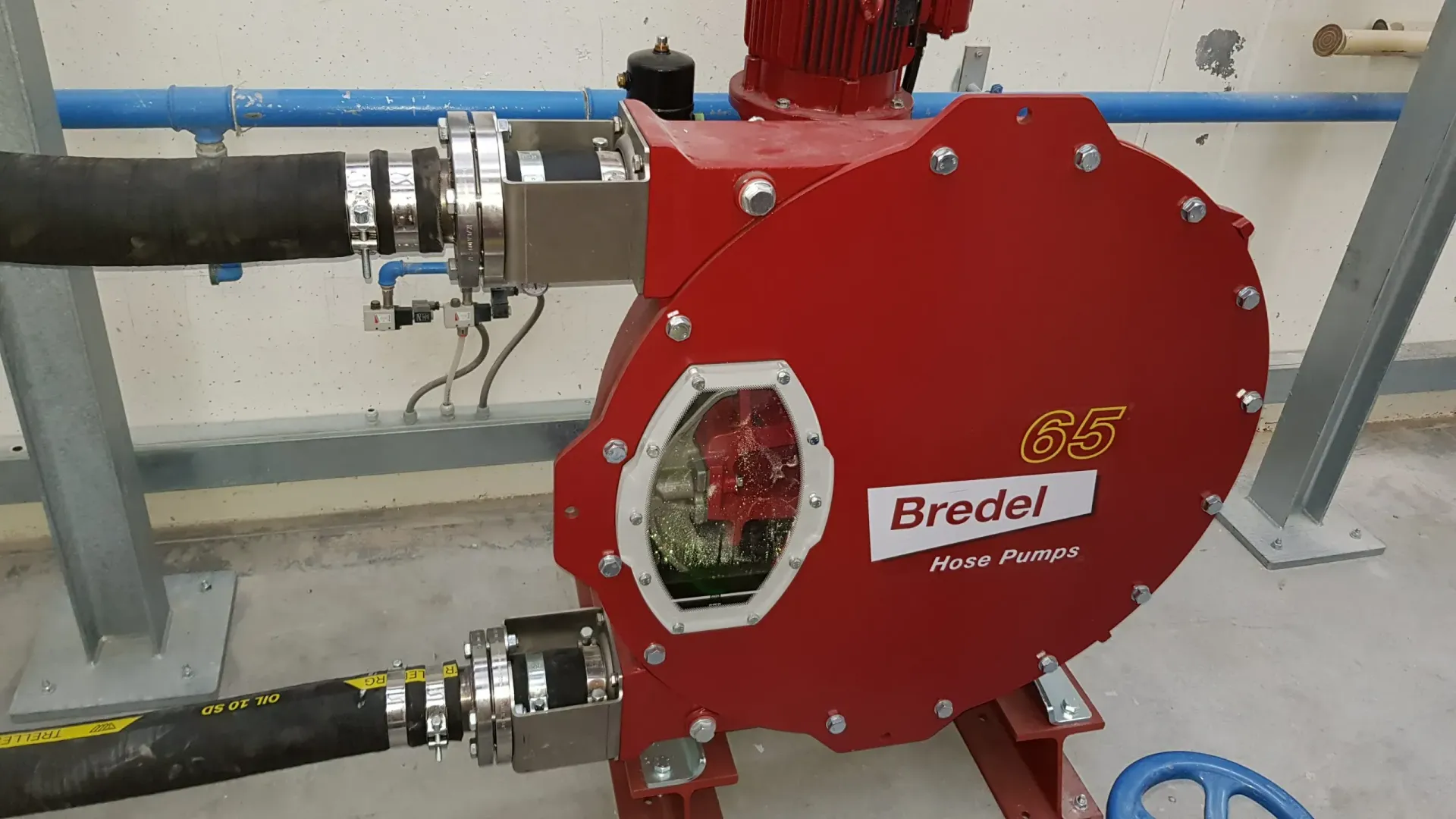 Pompa a tubo flessibile Bredal rossa con tubi di collegamento e valvola blu.