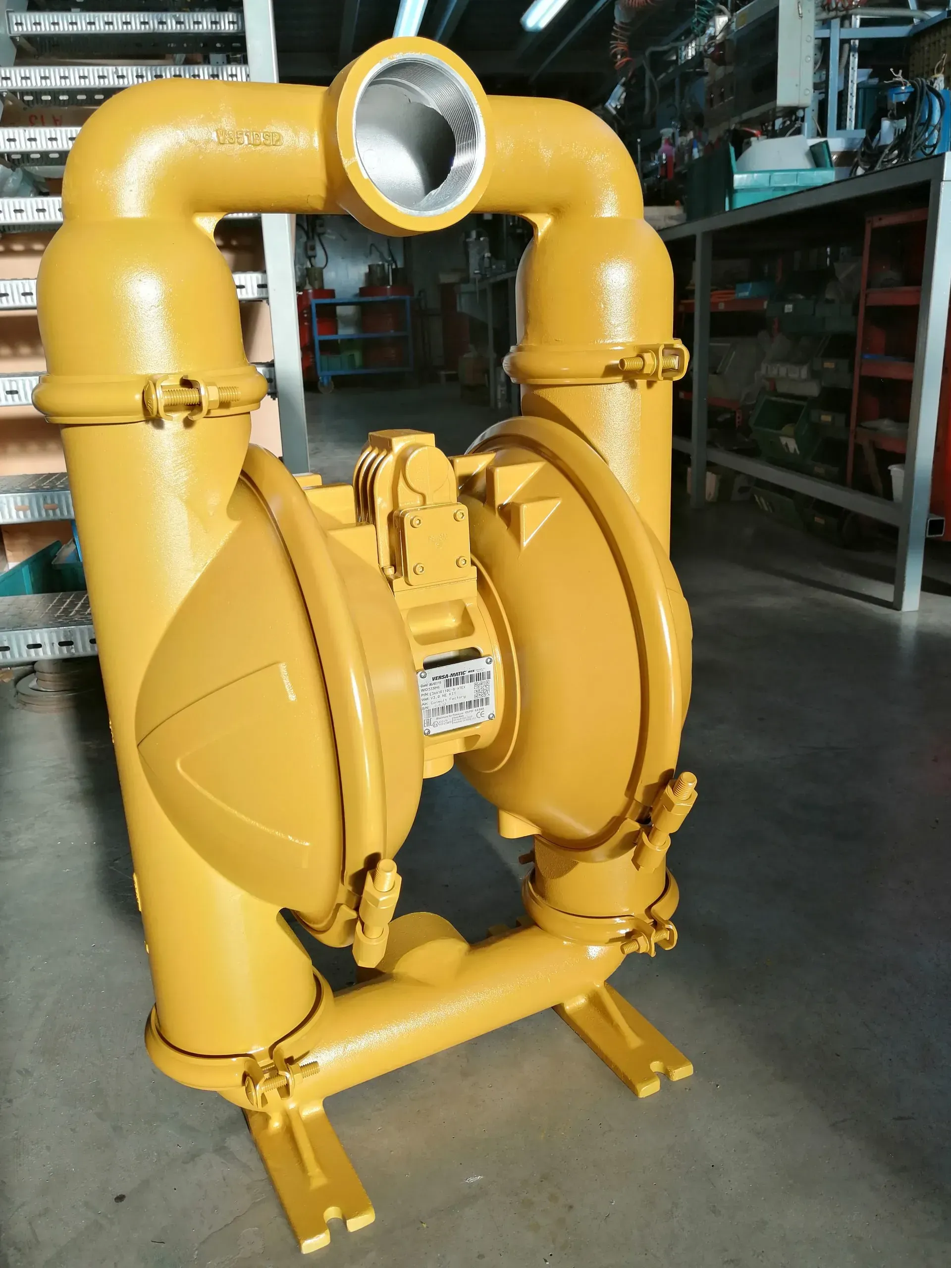 Pompa pneumatica gialla a doppia membrana con camere cilindriche e tubazioni.