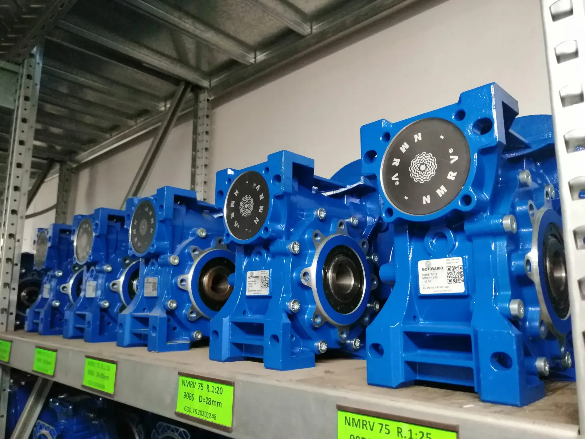 Riduttori industriali blu su uno scaffale in un magazzino.