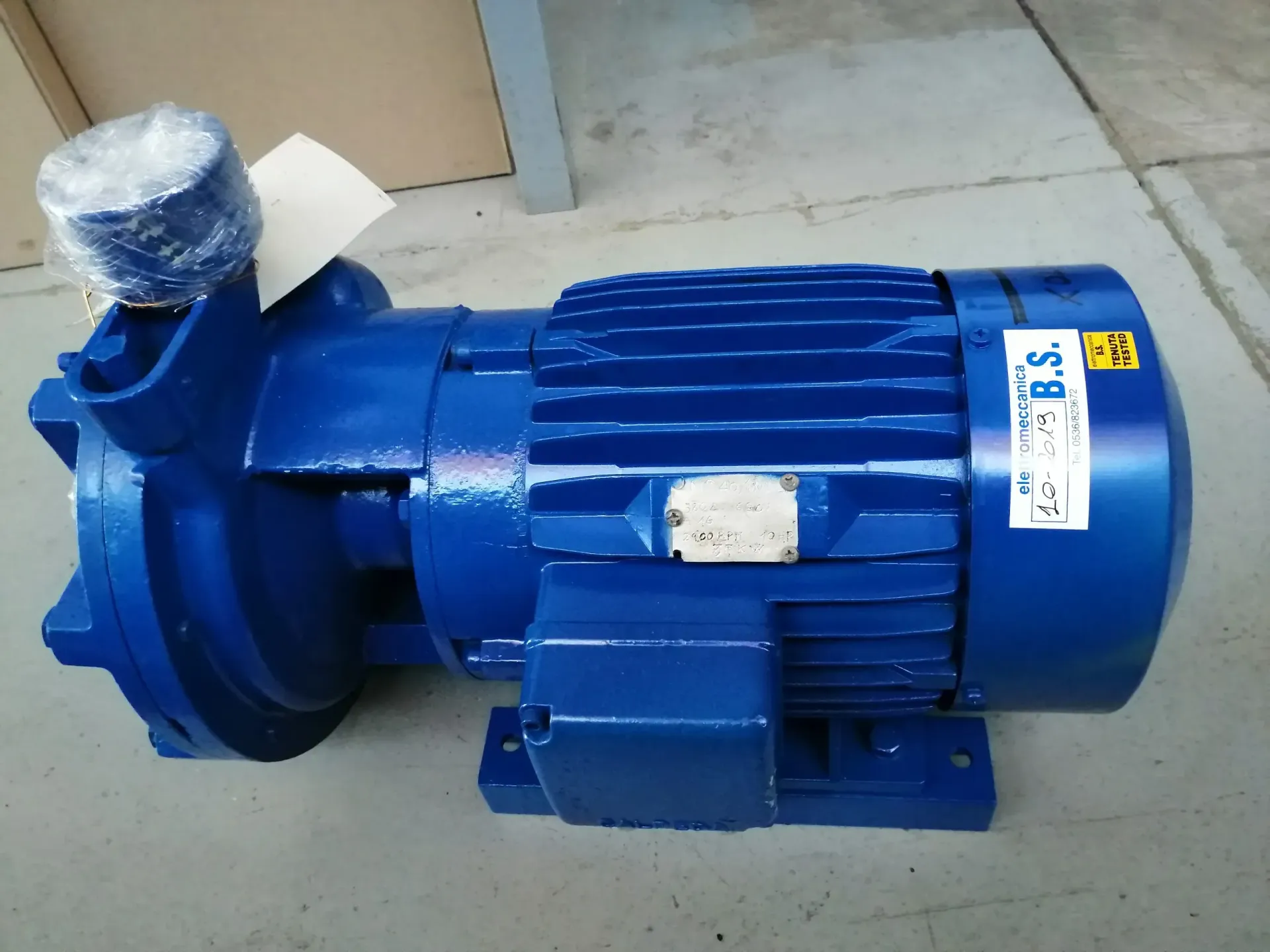 Pompa idrica industriale blu su pavimento in cemento.