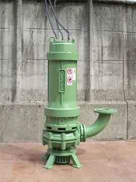 Pompa sommersa verde con tubo di scarico curvo, contro un muro di cemento.