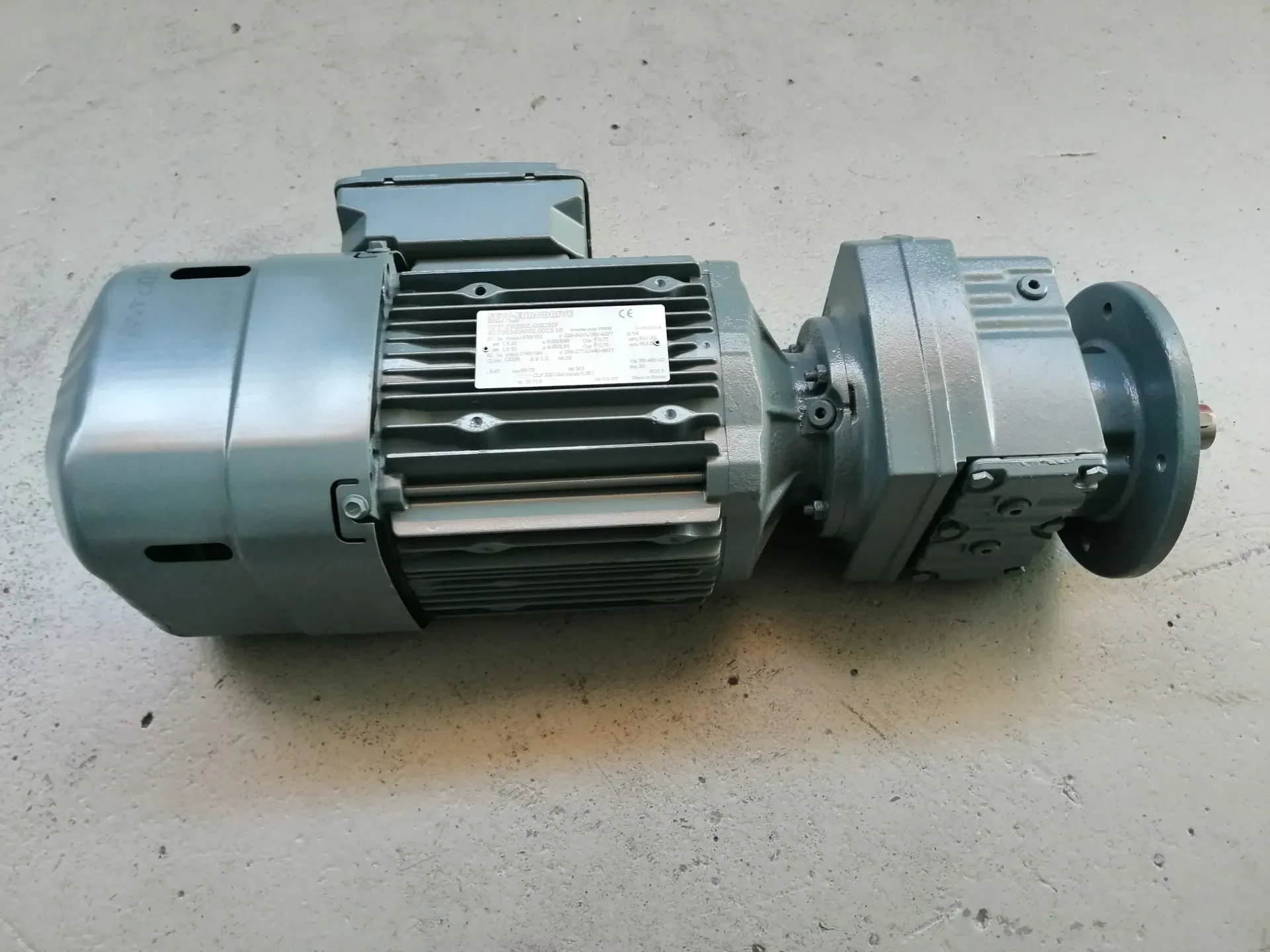 Motore elettrico con involucro grigio e riduttore attaccato.