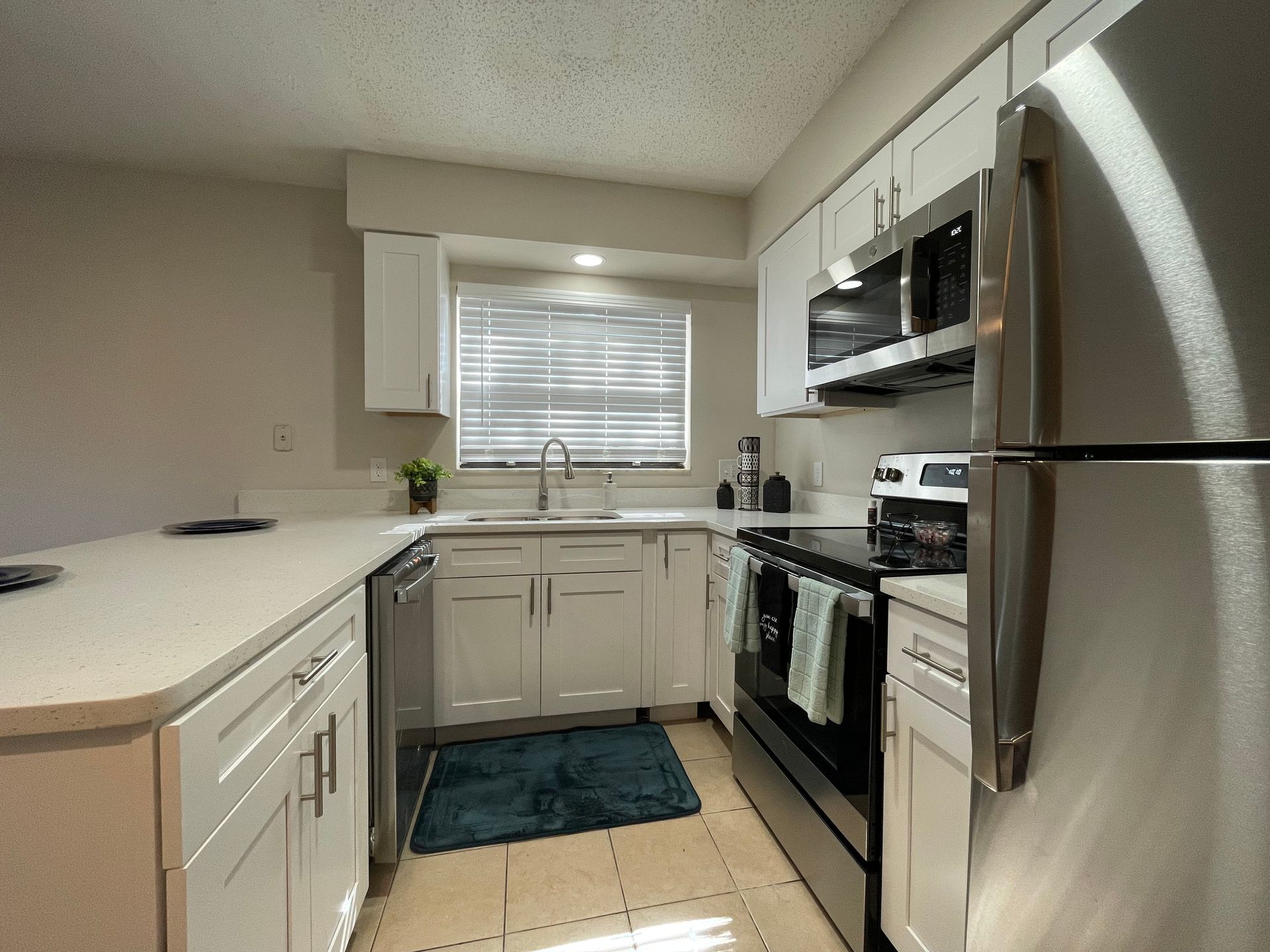 A kitchen with stainless steel appliances and white cabinets.