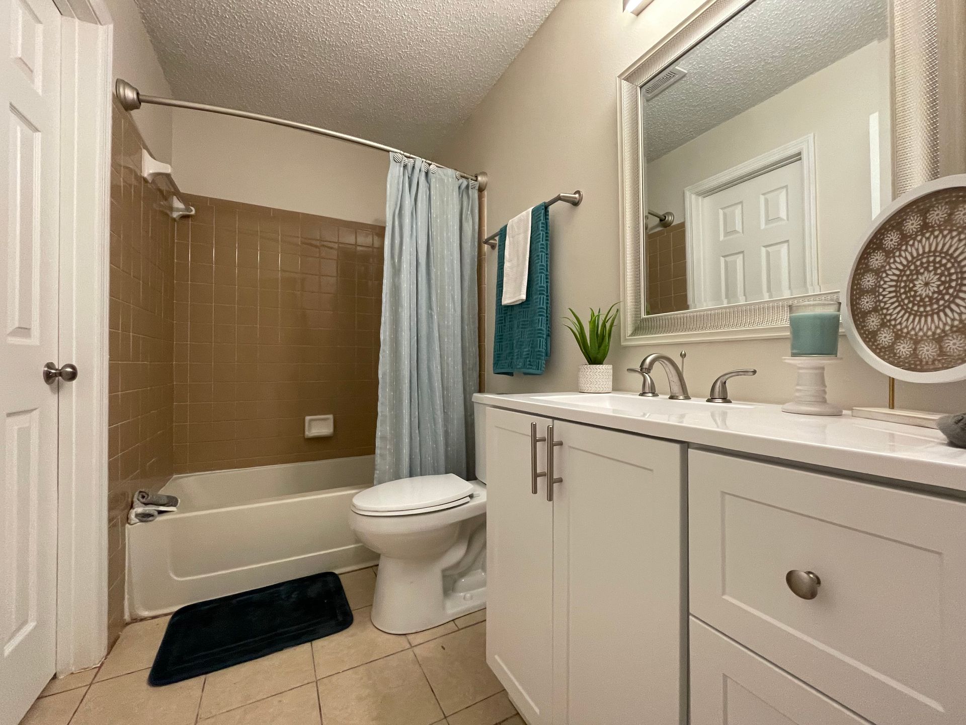 A bathroom with a toilet, sink, bathtub and mirror.