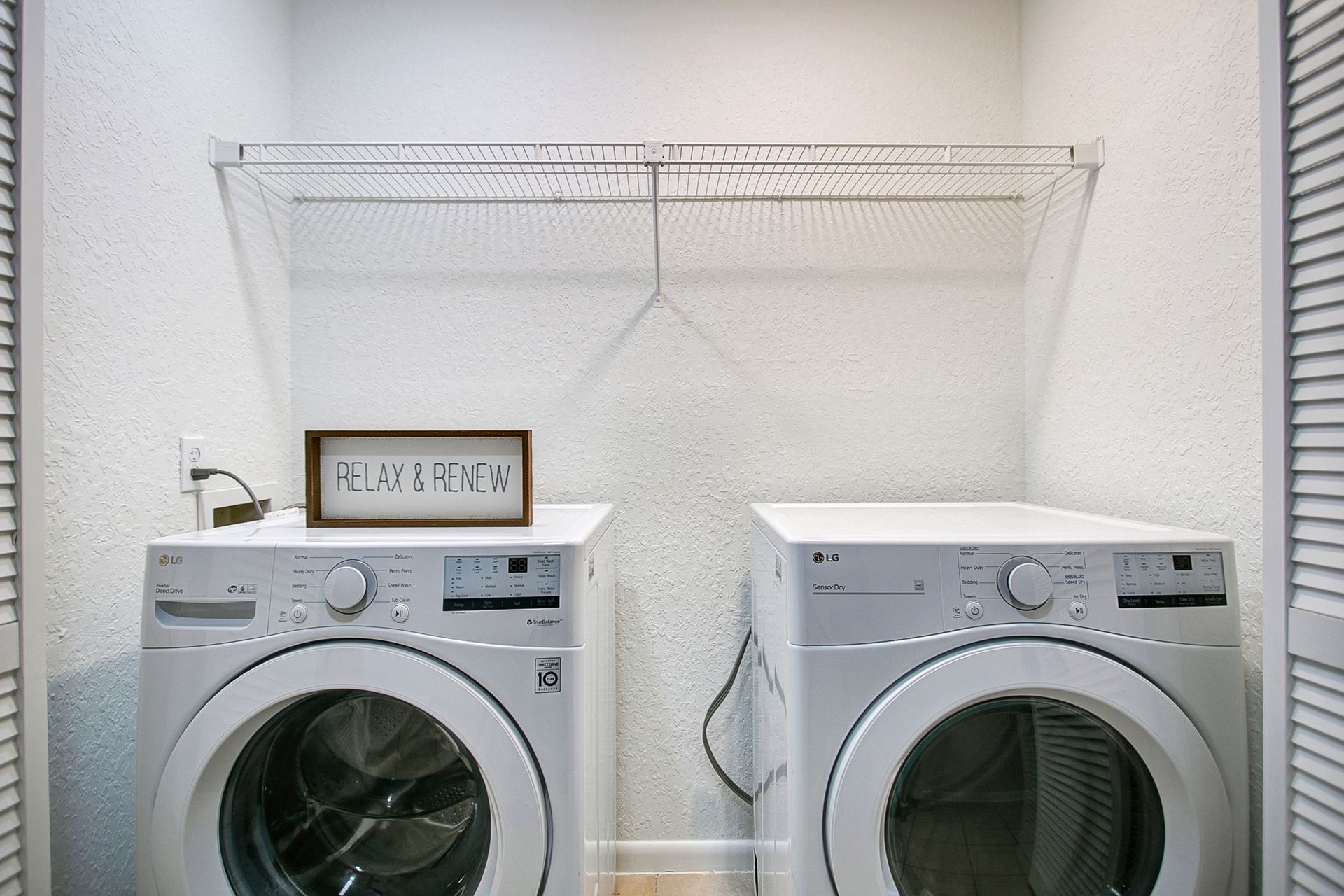 There are two washers and dryers in the laundry room.