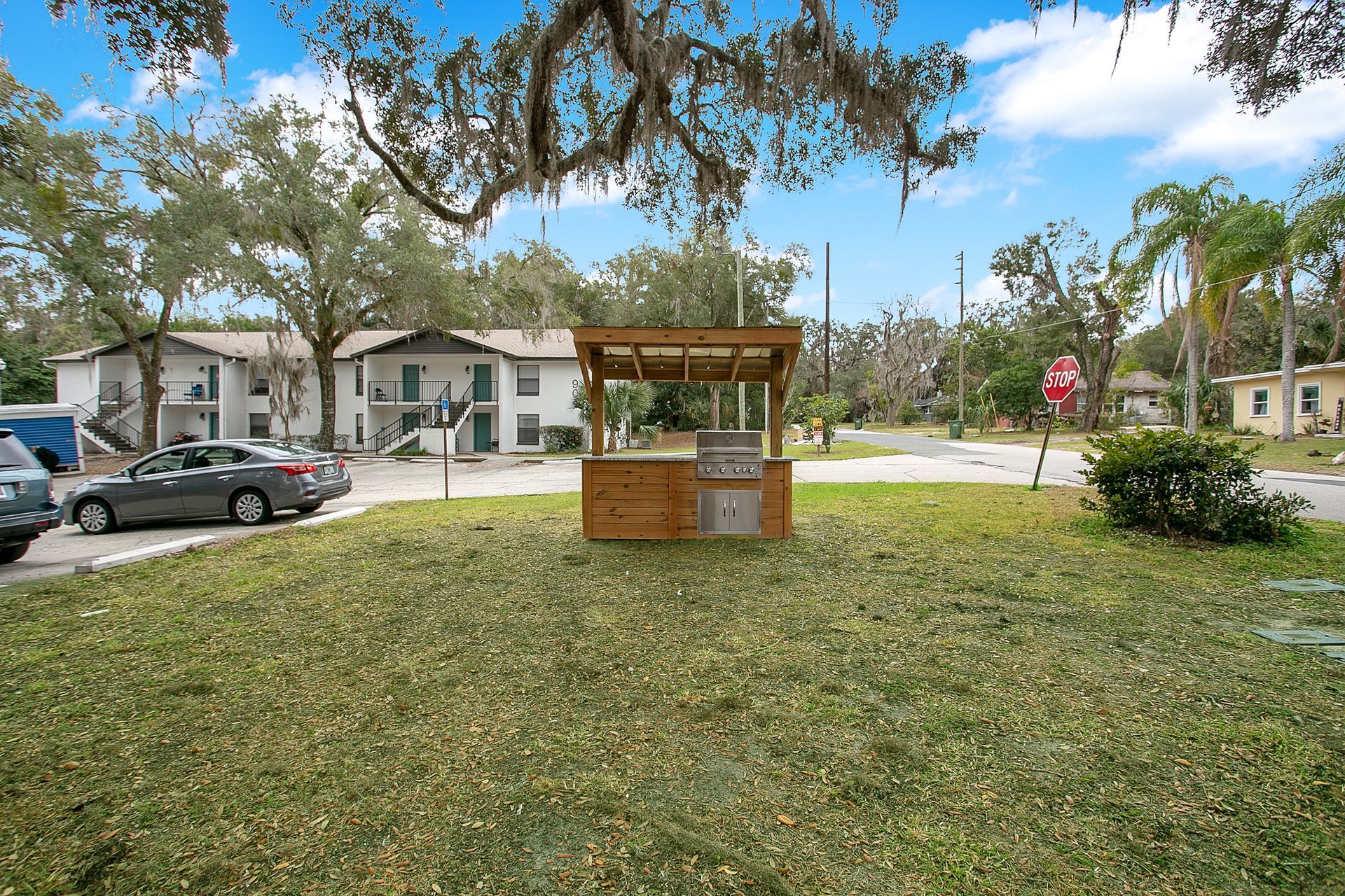 A wooden gazebo is sitting in the middle of a lush green field.