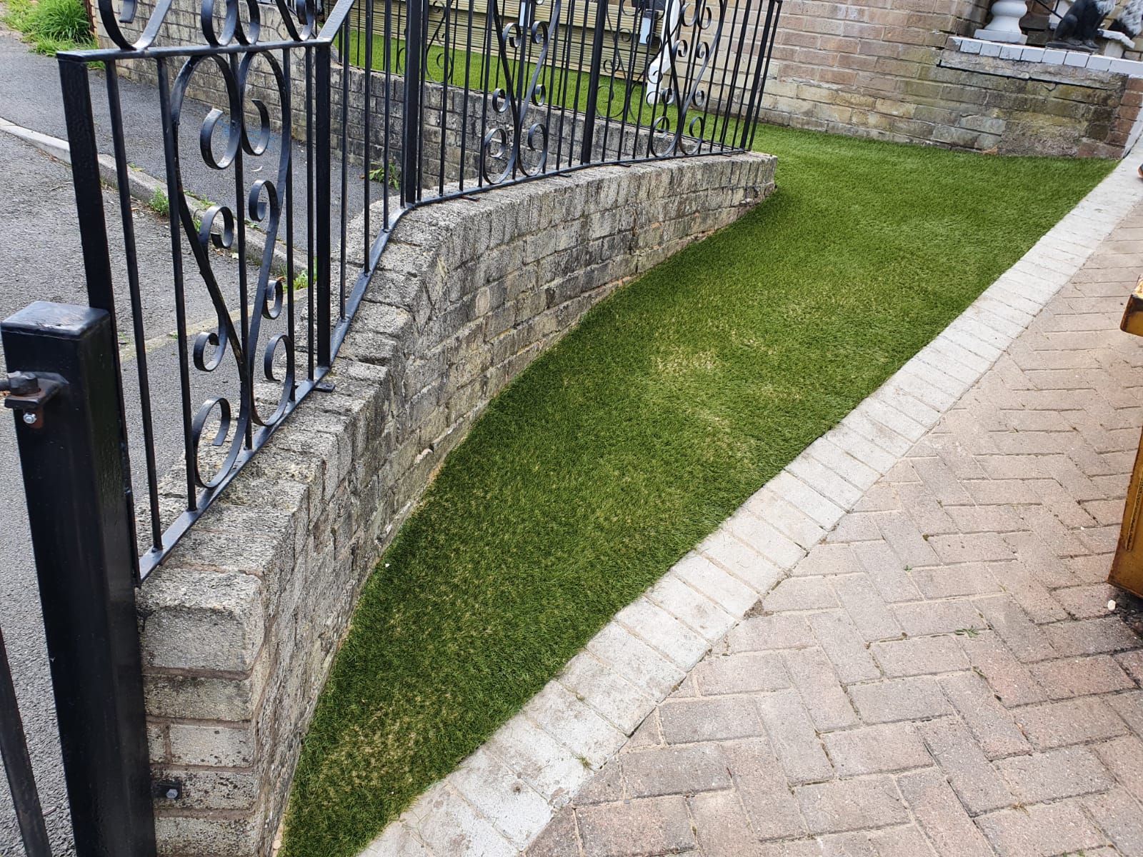 Small tidy artificial grass lawn along wall in Woodhouse Sheffield