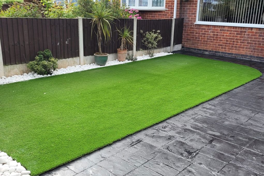 Zest Artificial Grass Luton new fake lawn fitted along a flower bed and imprinted concrete paving