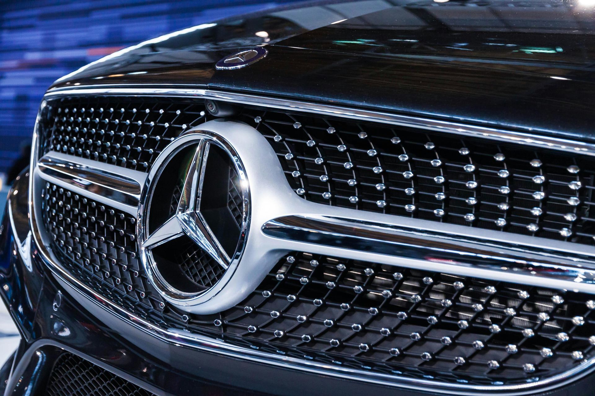 A close up of a mercedes logo on the front of a car