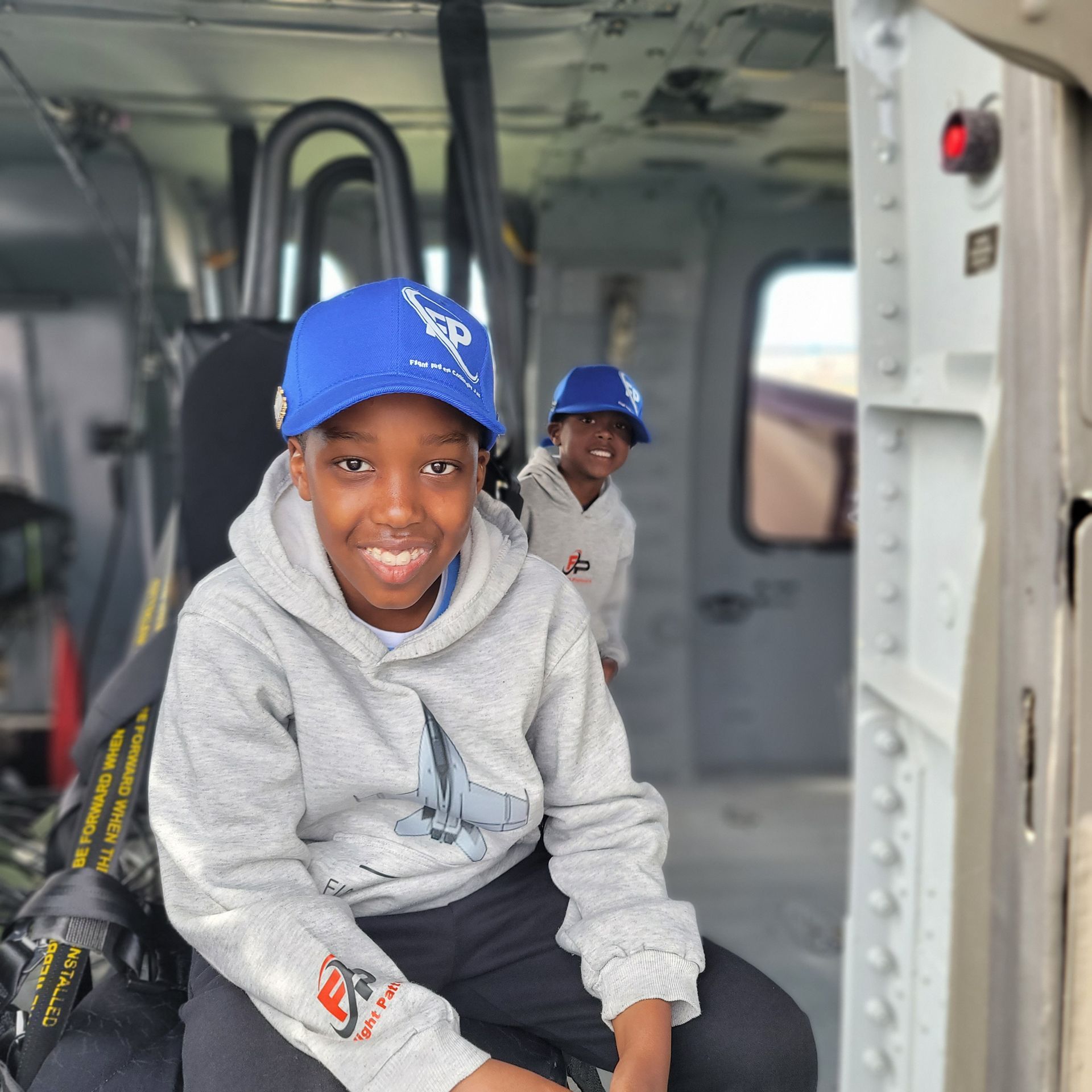 Jaxon Prear sits inside a helicopter with another child in back.