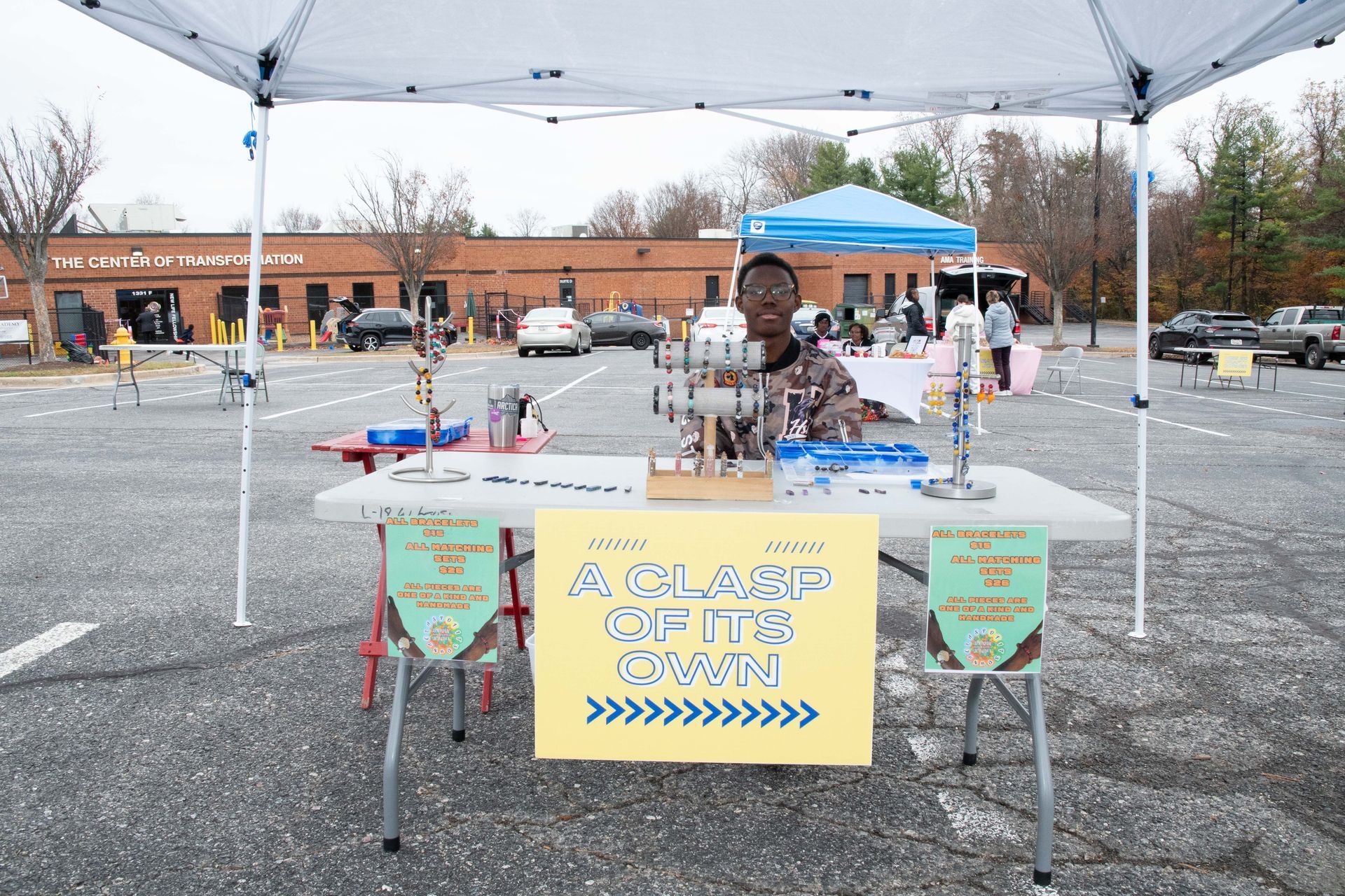 Outdoor camp booth with a yellow “Clean the air” sign under a canopy at a community event