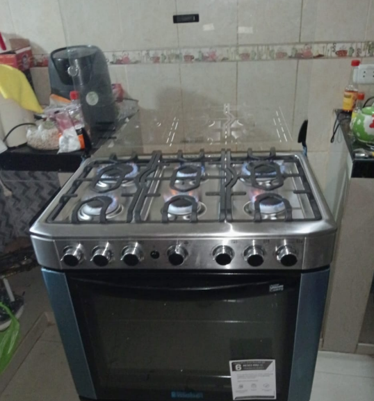 Cocina a gas de seis fuegos, horno, acero inoxidable, en cocina.