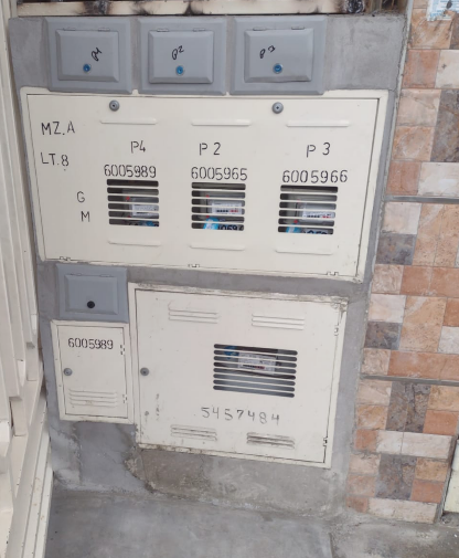 Contadores eléctricos montados en pared con múltiples compartimentos, numerados y etiquetados.