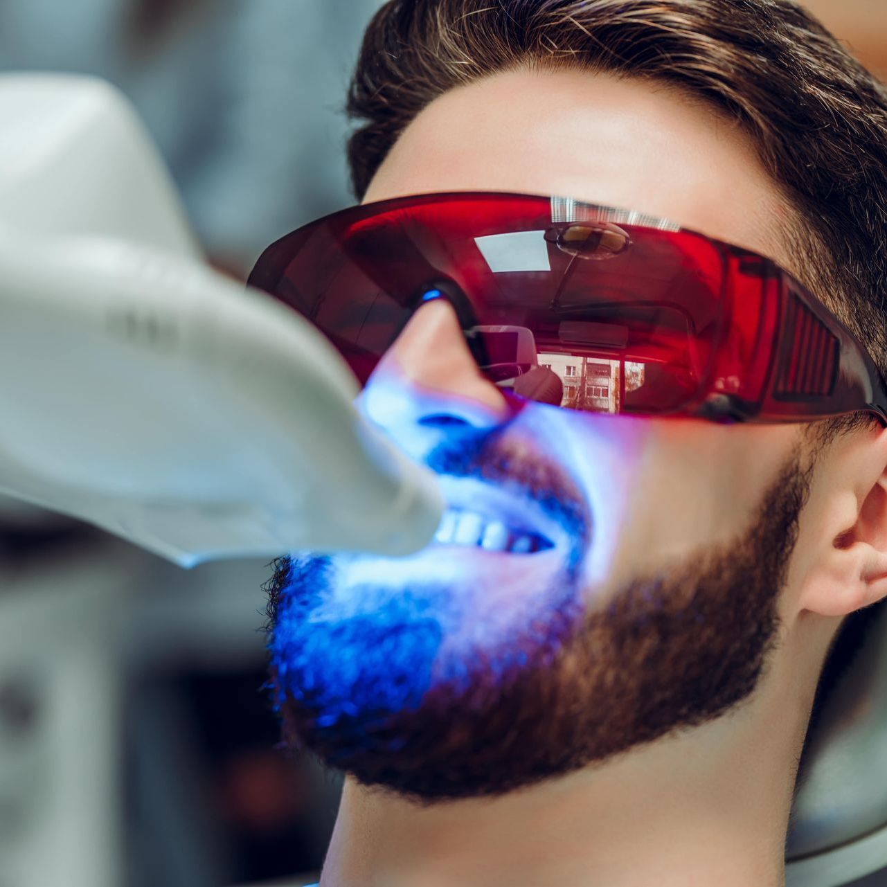 An image of a man wearing goggles during teeth whitening treatment