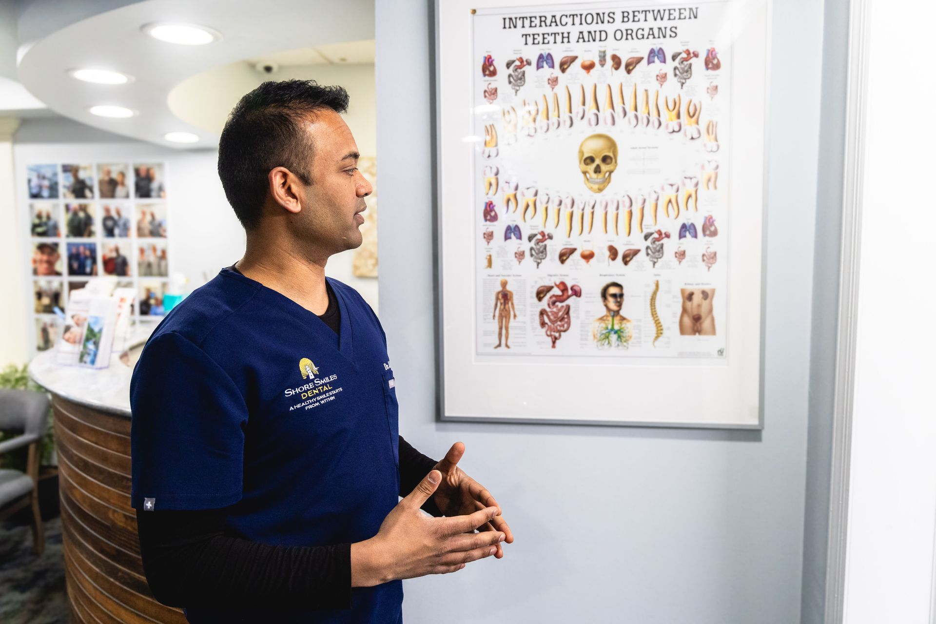 An image of Dr. Gandhi looking at a biological tooth chart