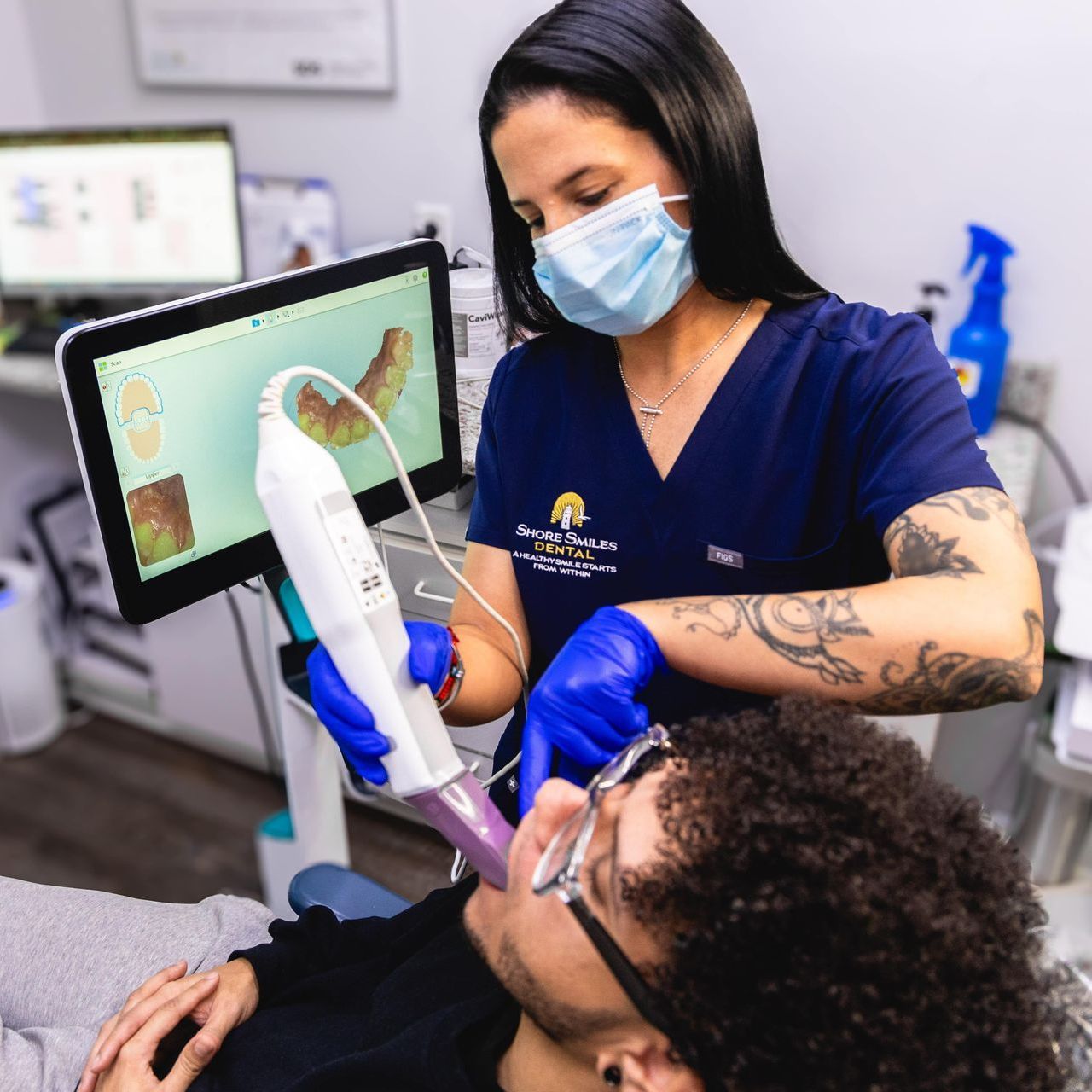 An image of a dental assistant performing an Invisalign® scan on a patient