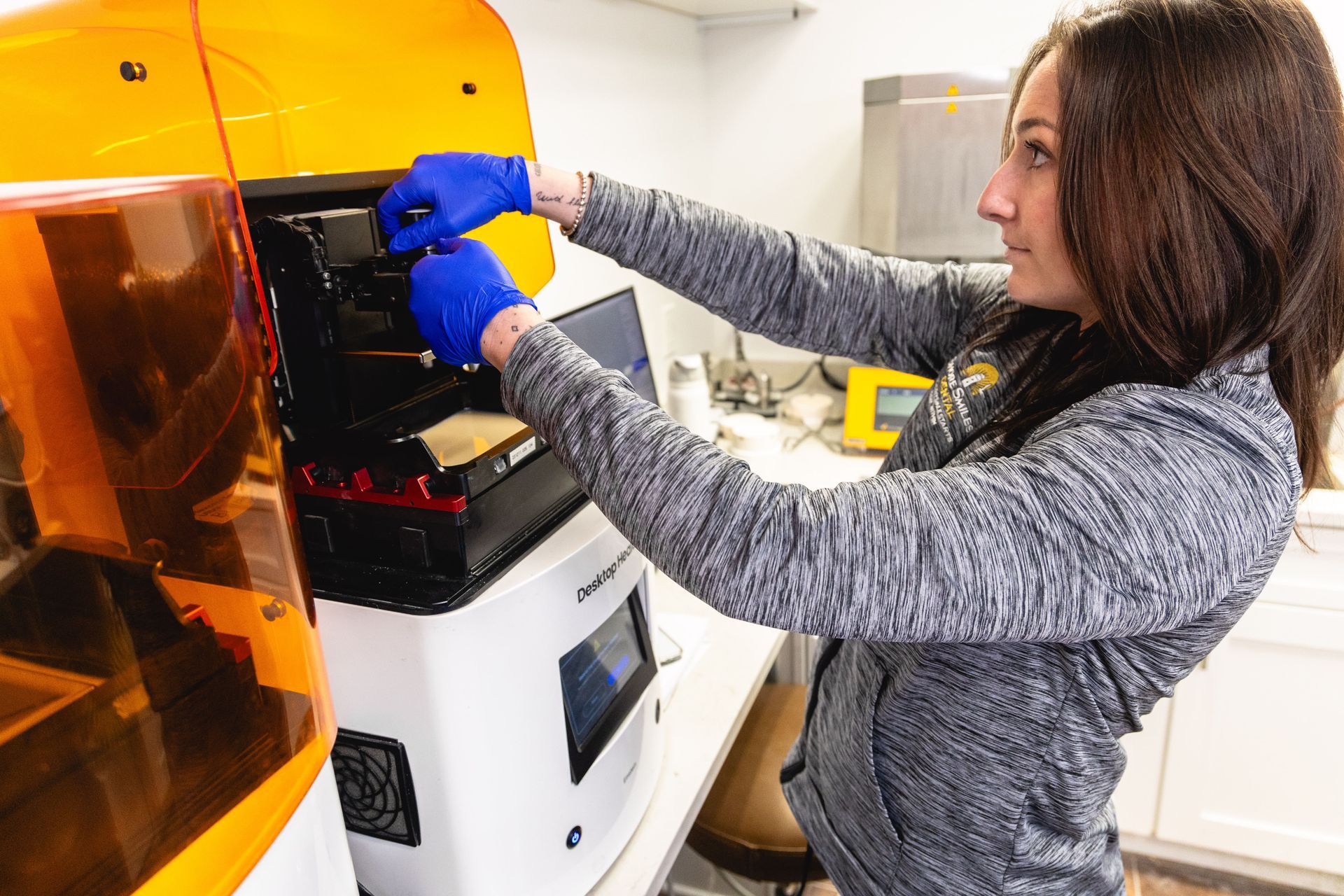An image of a lab technician preparing a 3D printing machine