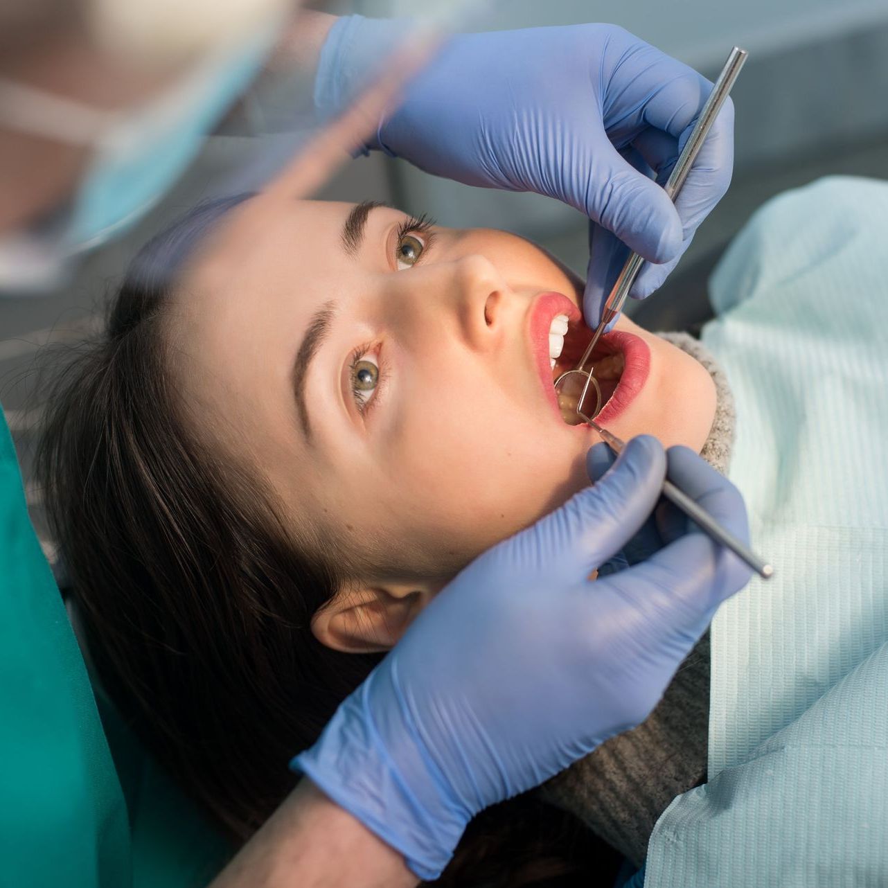 An image of a young woman and a dentist during a dental exam