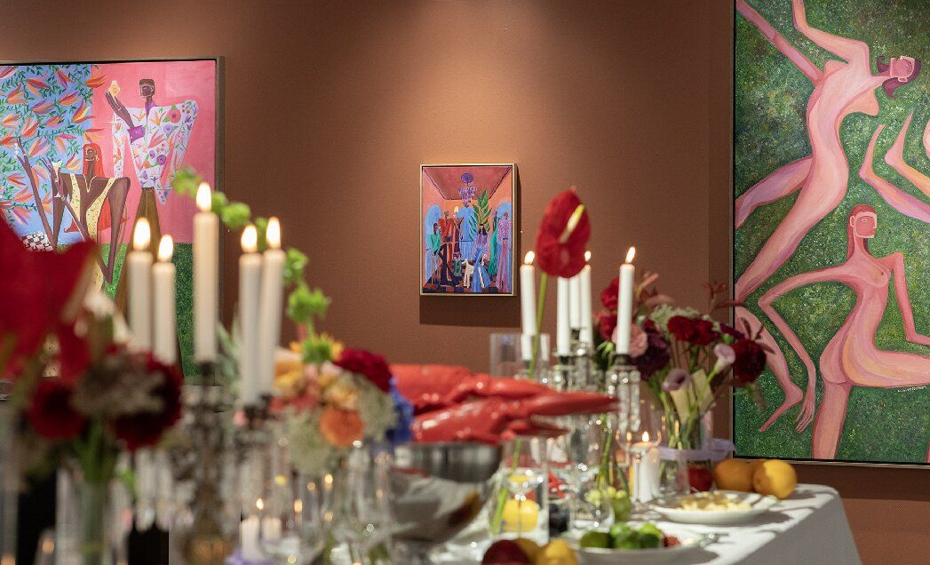 Stone building with red roof, overlooking a city and harbor, fall foliage.