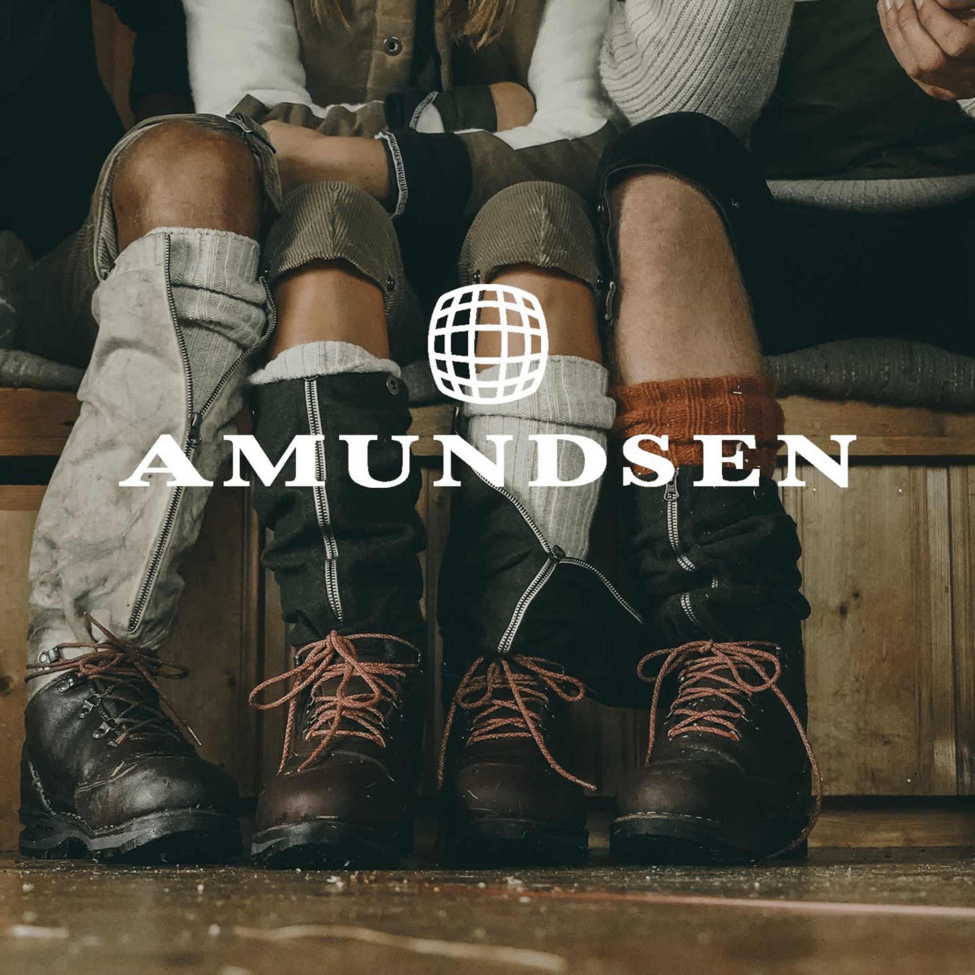 People wearing Amundsen boots, close-up.  Dark leather, red laces, warm socks, in a wooden setting.