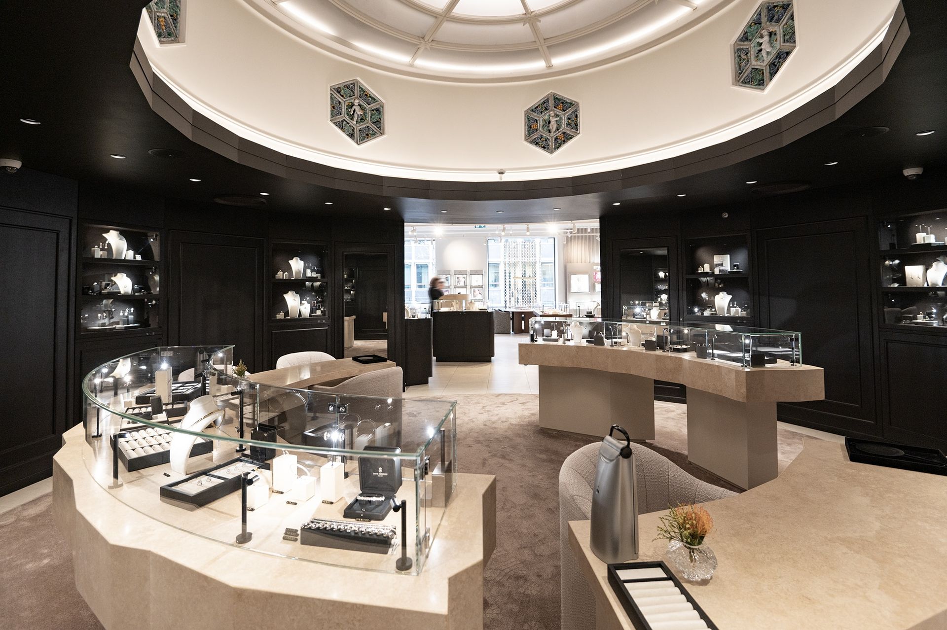 Jewelry store interior with display cases, beige counters, and a domed ceiling.