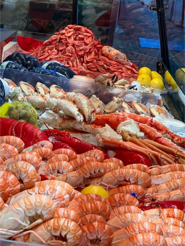 Seafood display: shrimp, crab legs, lobster, and lemons.
