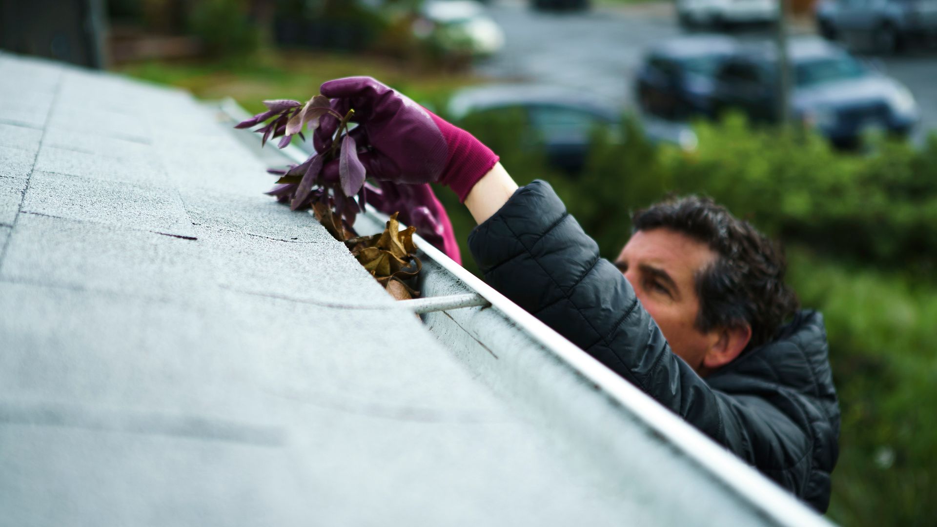 A man cleaning debris from gutters