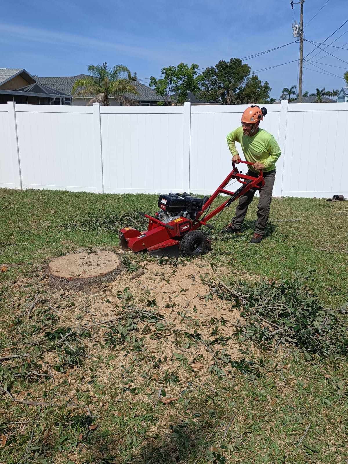 A man is using a stump grinder to remove a tree stump.