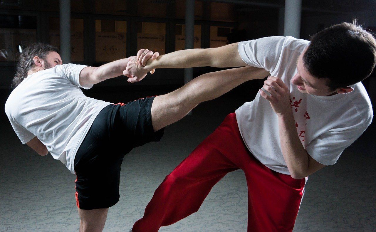 Twee mannen beoefenen vechtsporten in een sportschool.