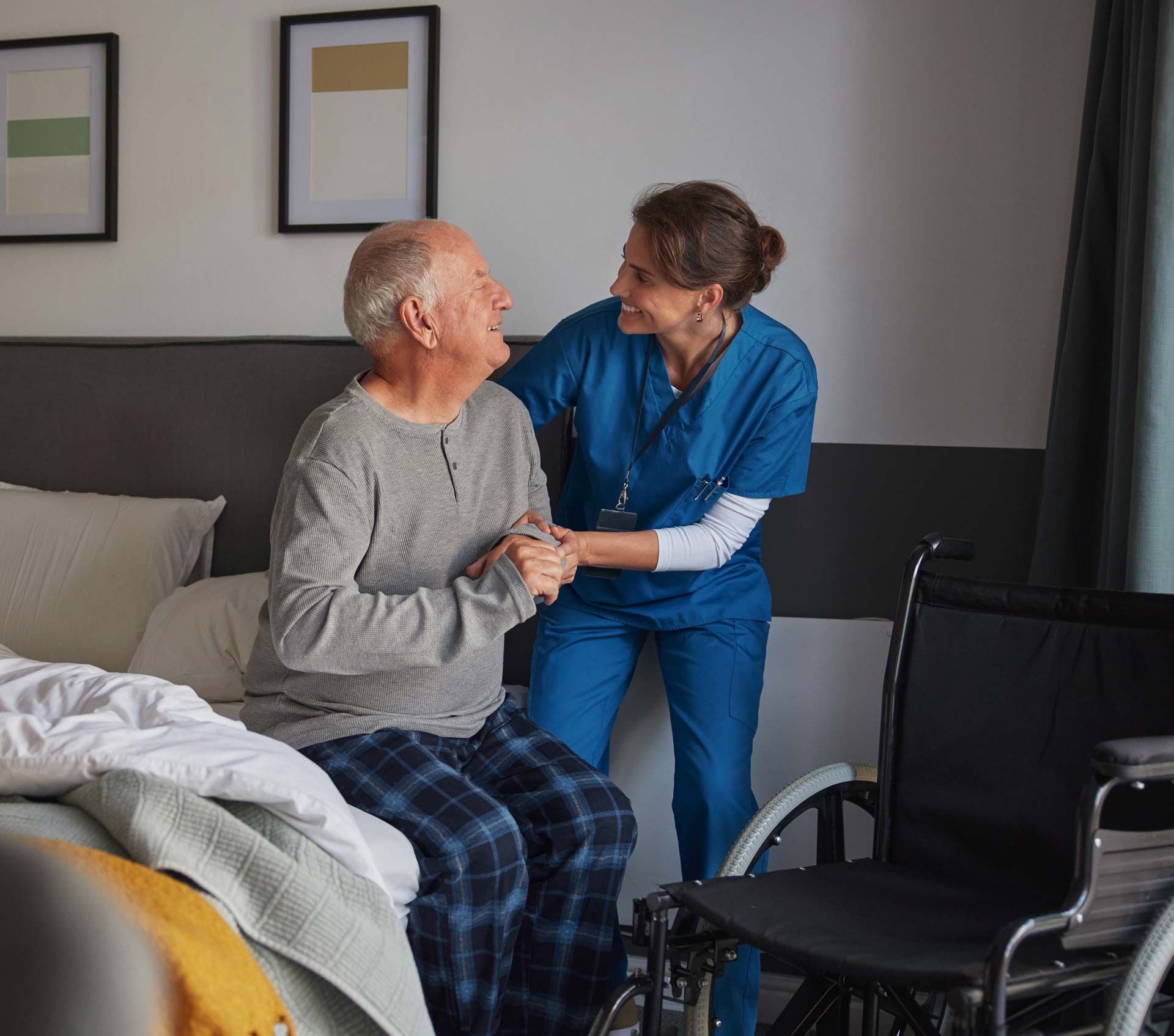 Woman assisting an older person from bed. 