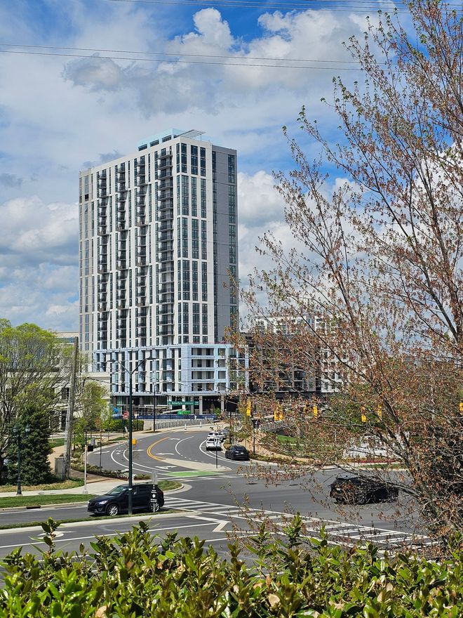 A tall building is sitting on top of a city street.