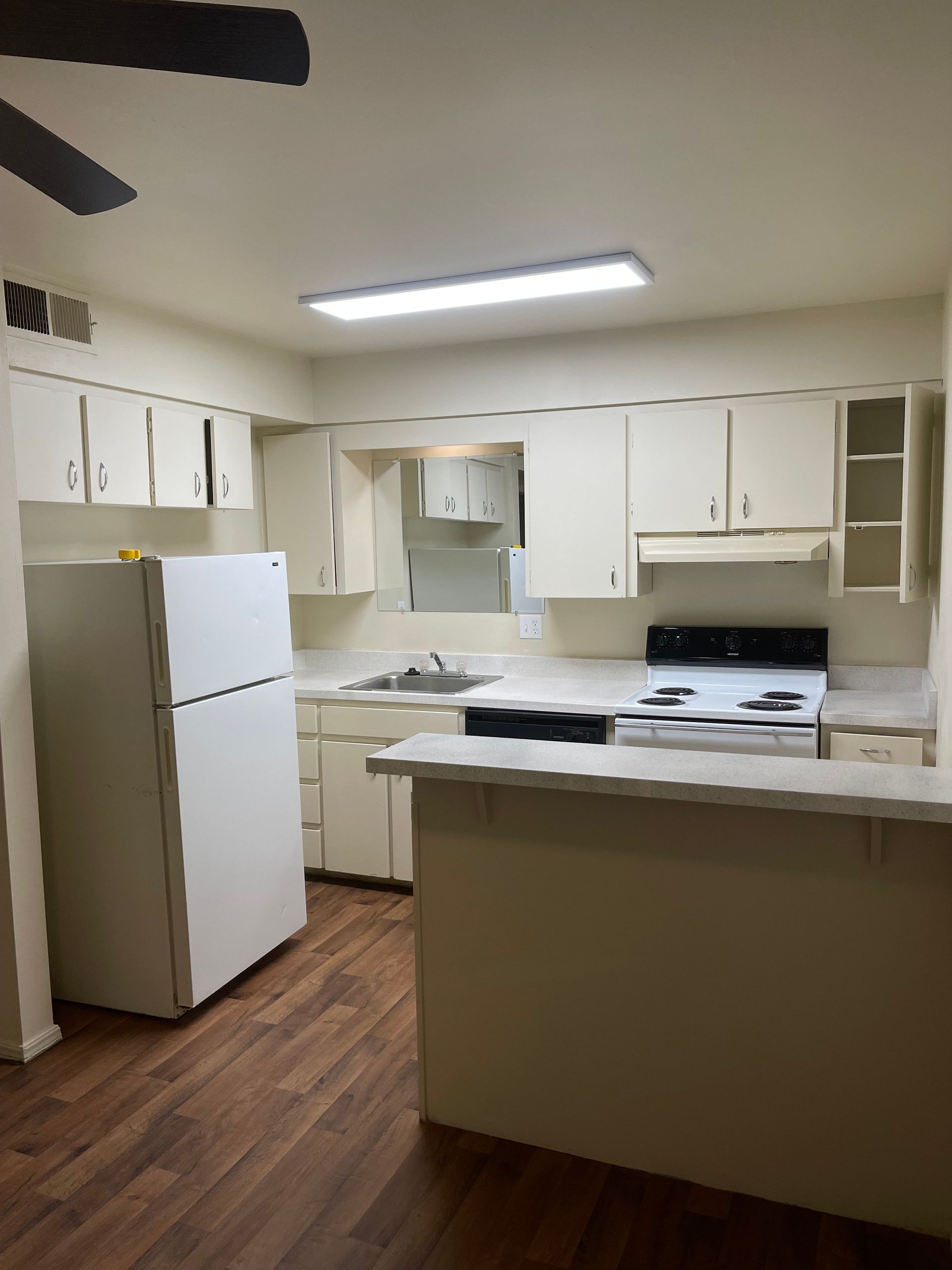 A kitchen with white cabinets and a white refrigerator