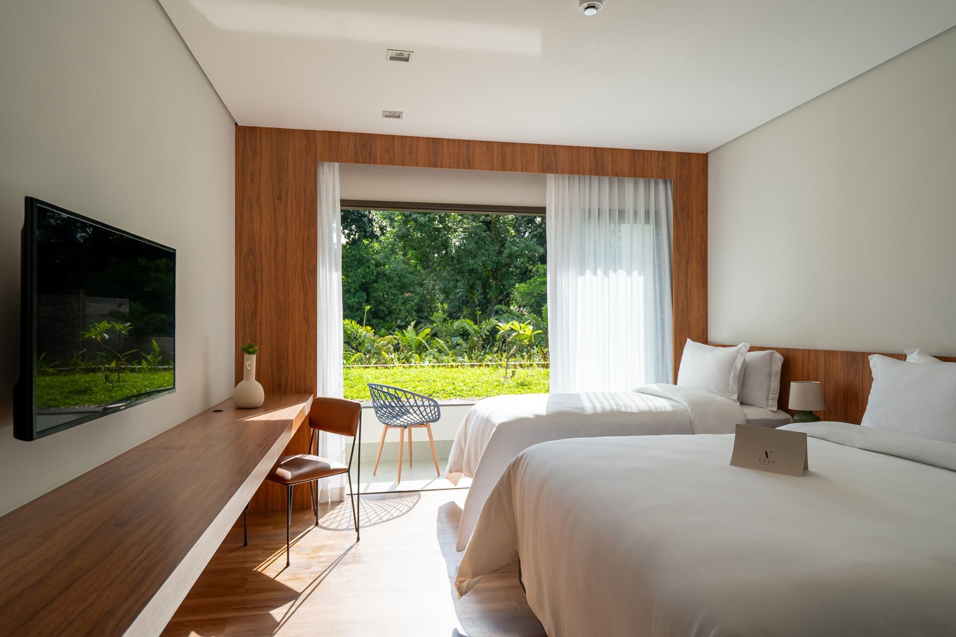 Um quarto de hotel com duas camas e uma TV de tela plana.