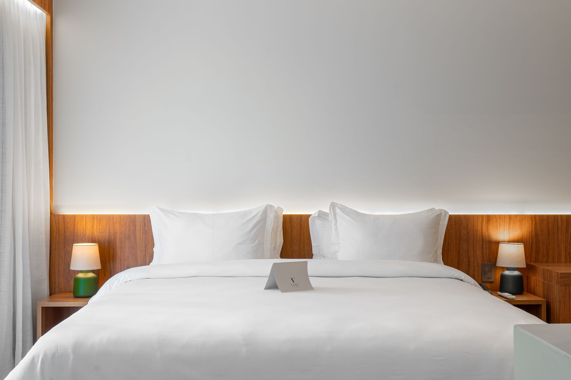 Um quarto de hotel com uma cama king size e um tablet na cama.