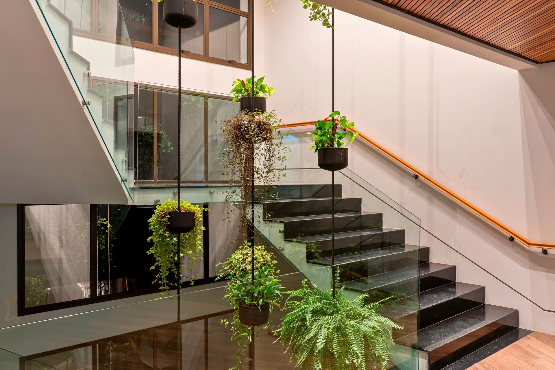 Uma escada com vasos de plantas pendurados no corrimão.