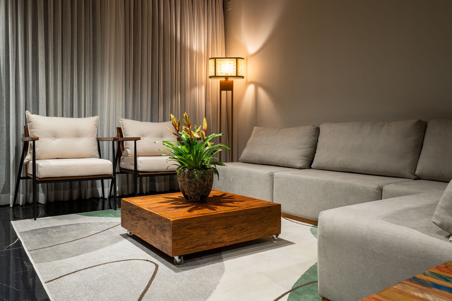 Uma sala de estar com um sofá, cadeiras e uma mesa de centro.