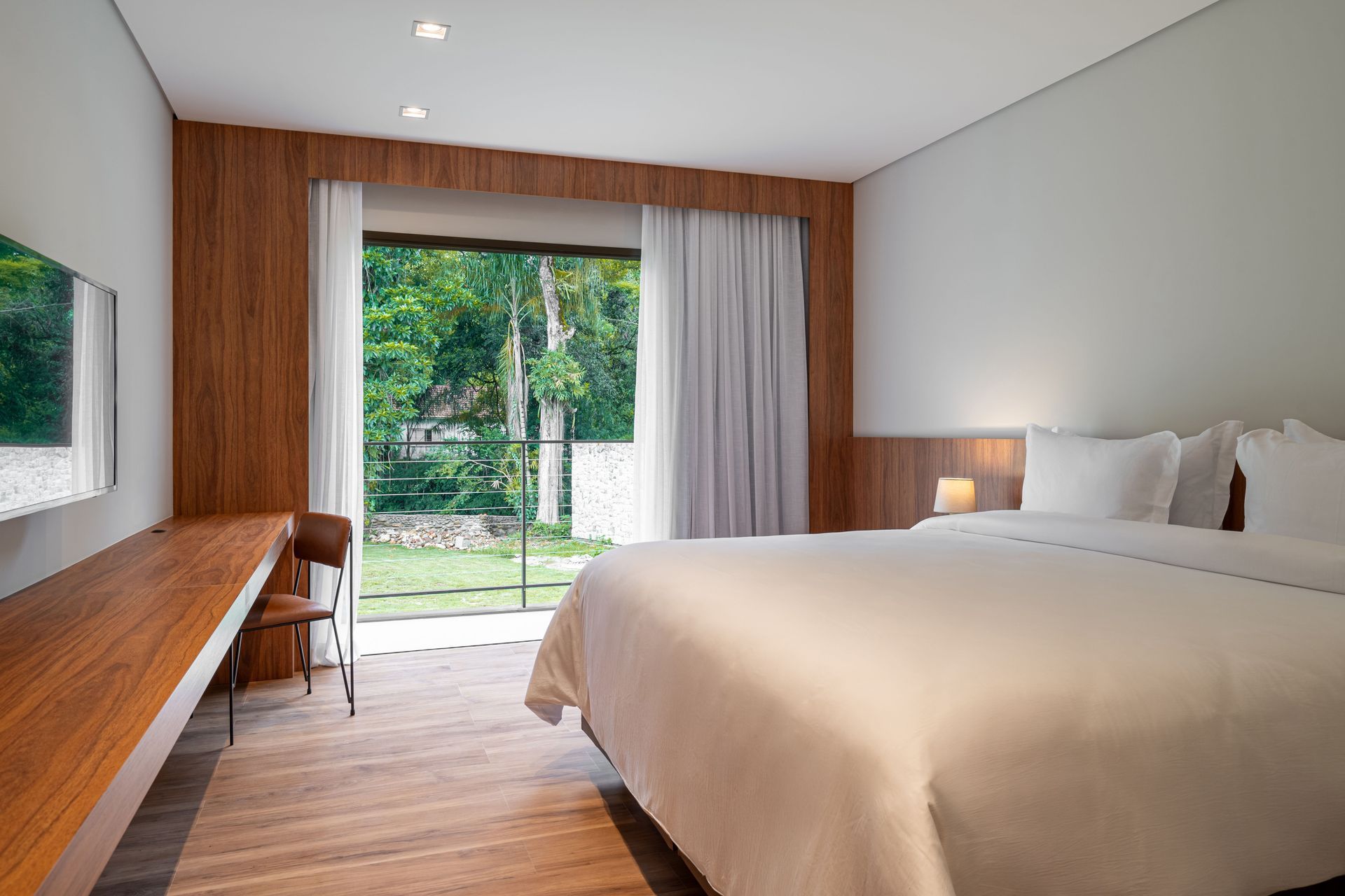 Um quarto de hotel com uma cama grande e uma porta de vidro deslizante.